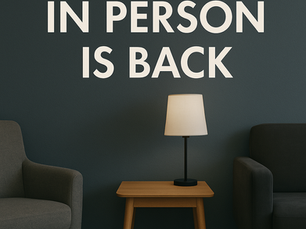 The office background is a soft light gray wall, creating a calm, neutral setting that suggests an in person therapy session without showing any faces.