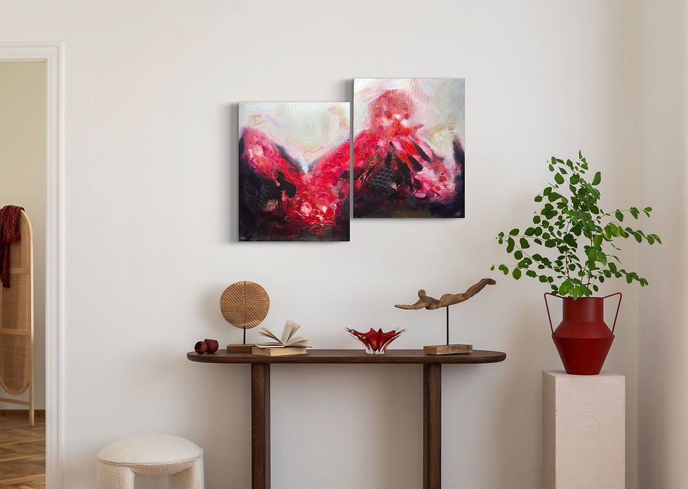 Two paintings with red and white abstract art over a wooden table.