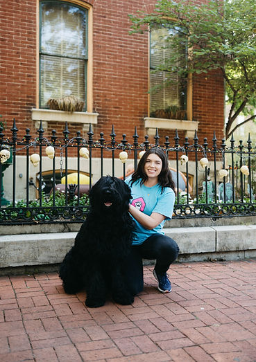 House of Paws professional dog walker with a large black dog on a city street in St. Louis, MO