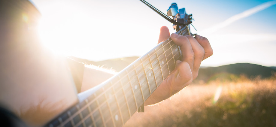 Guitar in the Morning Sun, playing a guitar ontop of a mountain during a music video shoot