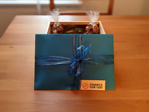 Finanzcoaching Gutschein im blauen Couvert mit blau-silbernem Geschenkband