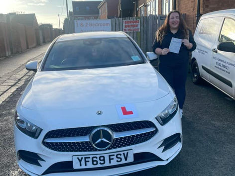 Driving school student showing test pass certificate proudly