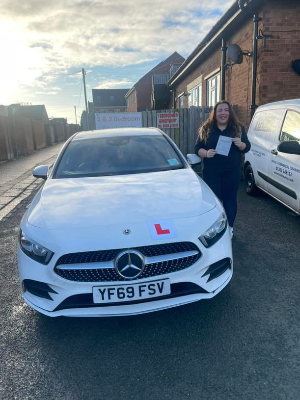 Driving school student showing test pass certificate proudly