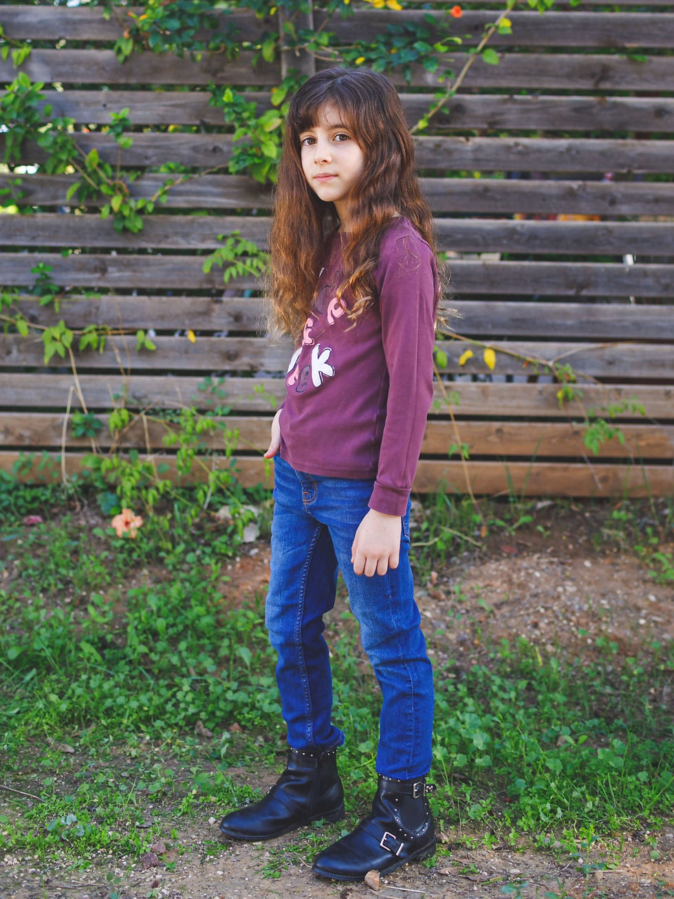 ילדה עם סוודר ועם ג'ינס כחולים