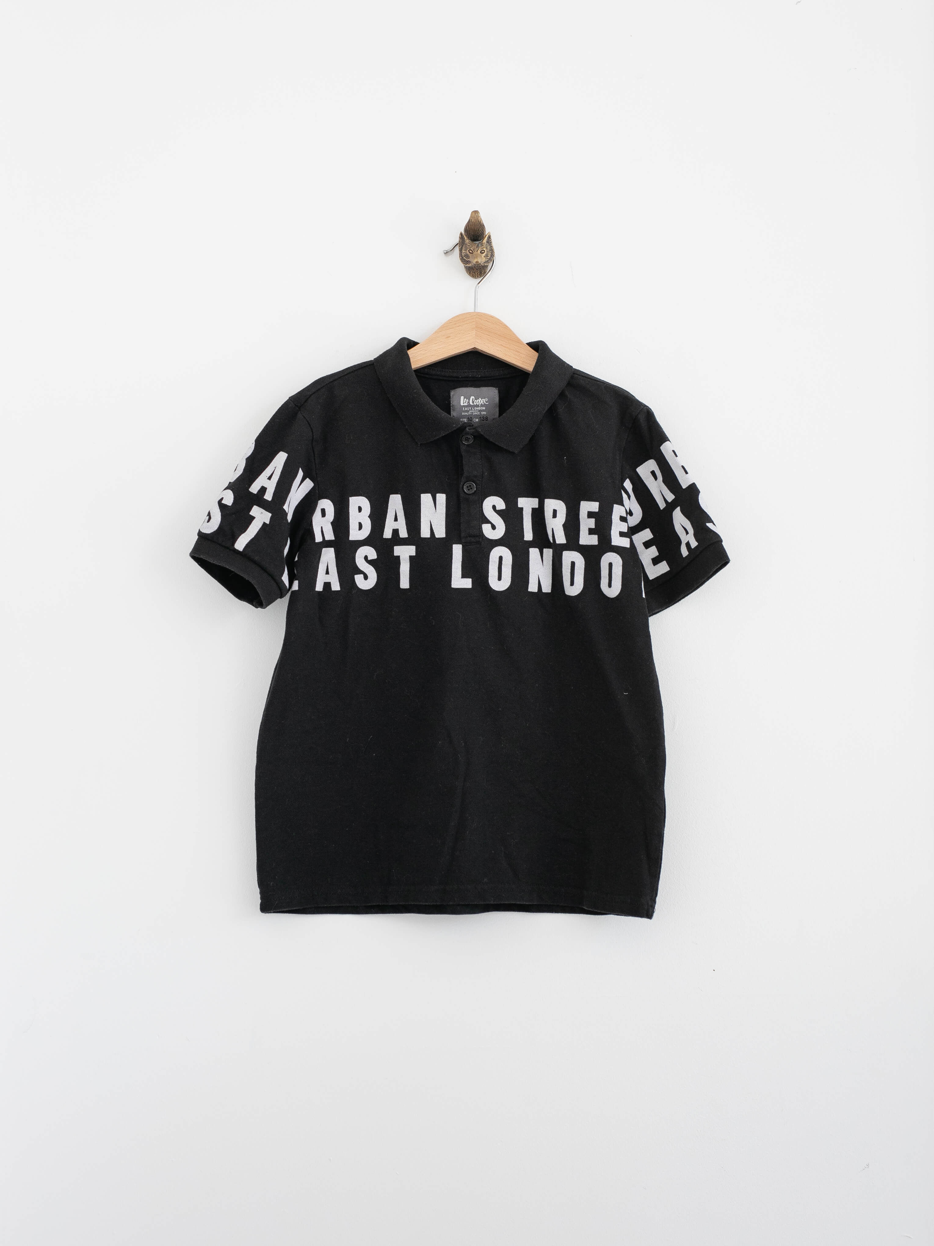 חולצת פולו שחורה עם כיתוב URBAN STREET EAST LONDON