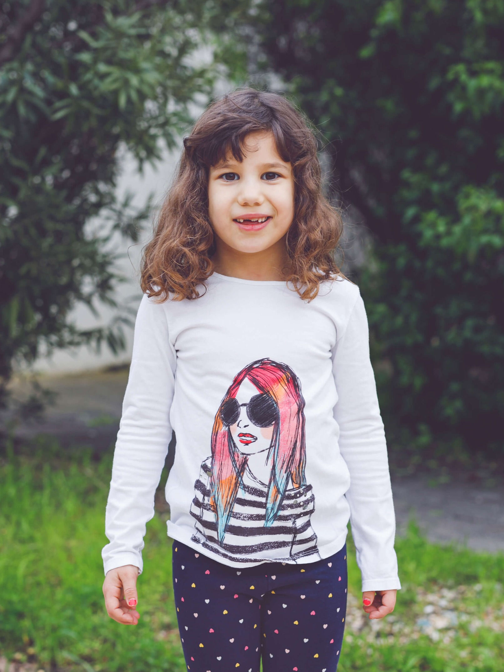 ילדה חמודה בחולצת טריקו לבנה עם הדפס