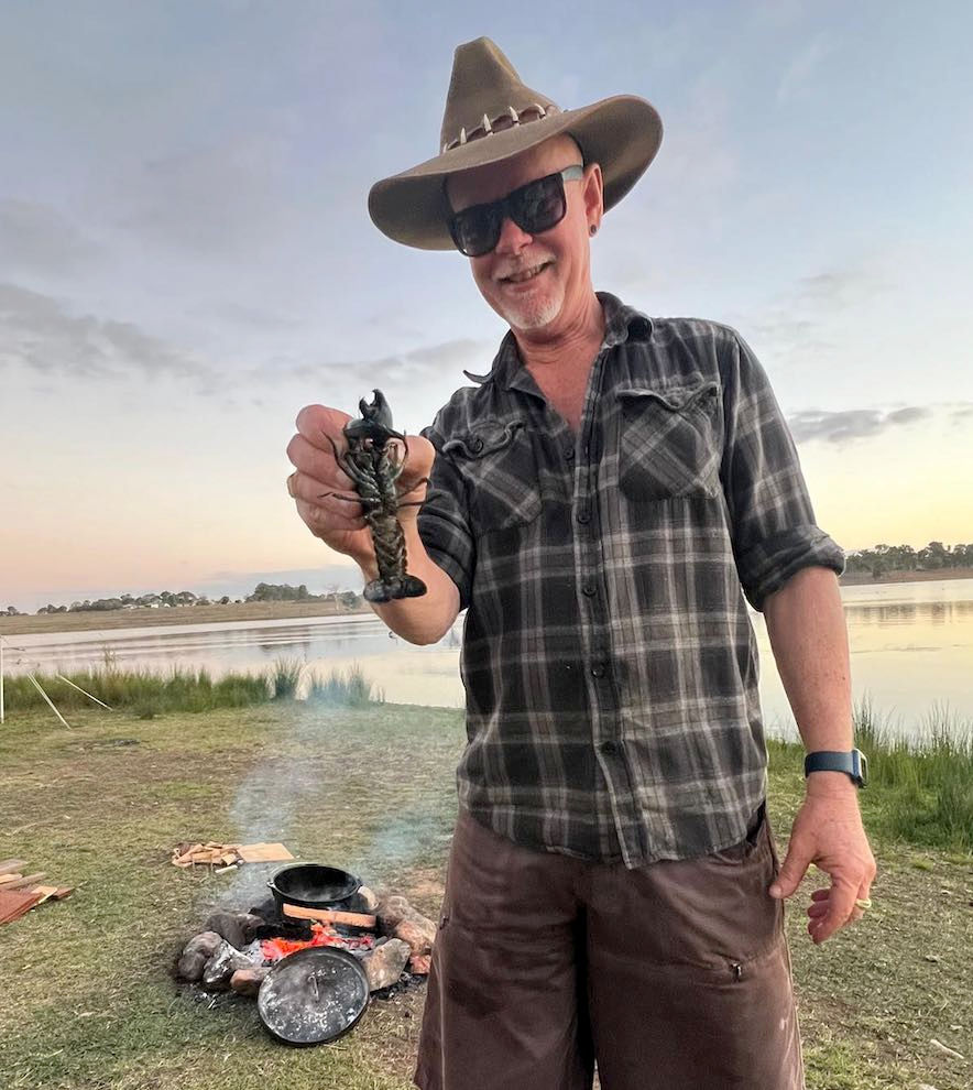 Myles Forsyth holding a freshly caught crab, embracing nature and the self-sufficient lifestyle his high ticket business allows.