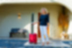 Sarah Hampel traveling with her suitcase, representing the freedom to make money while traveling and live life on her own terms through Prosperity Of Life.