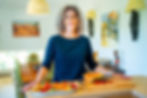 Sarah Hampel preparing a fresh fruit platter in her kitchen — enjoying the balance of home life and freedom that comes with knowing how to make money while traveling.