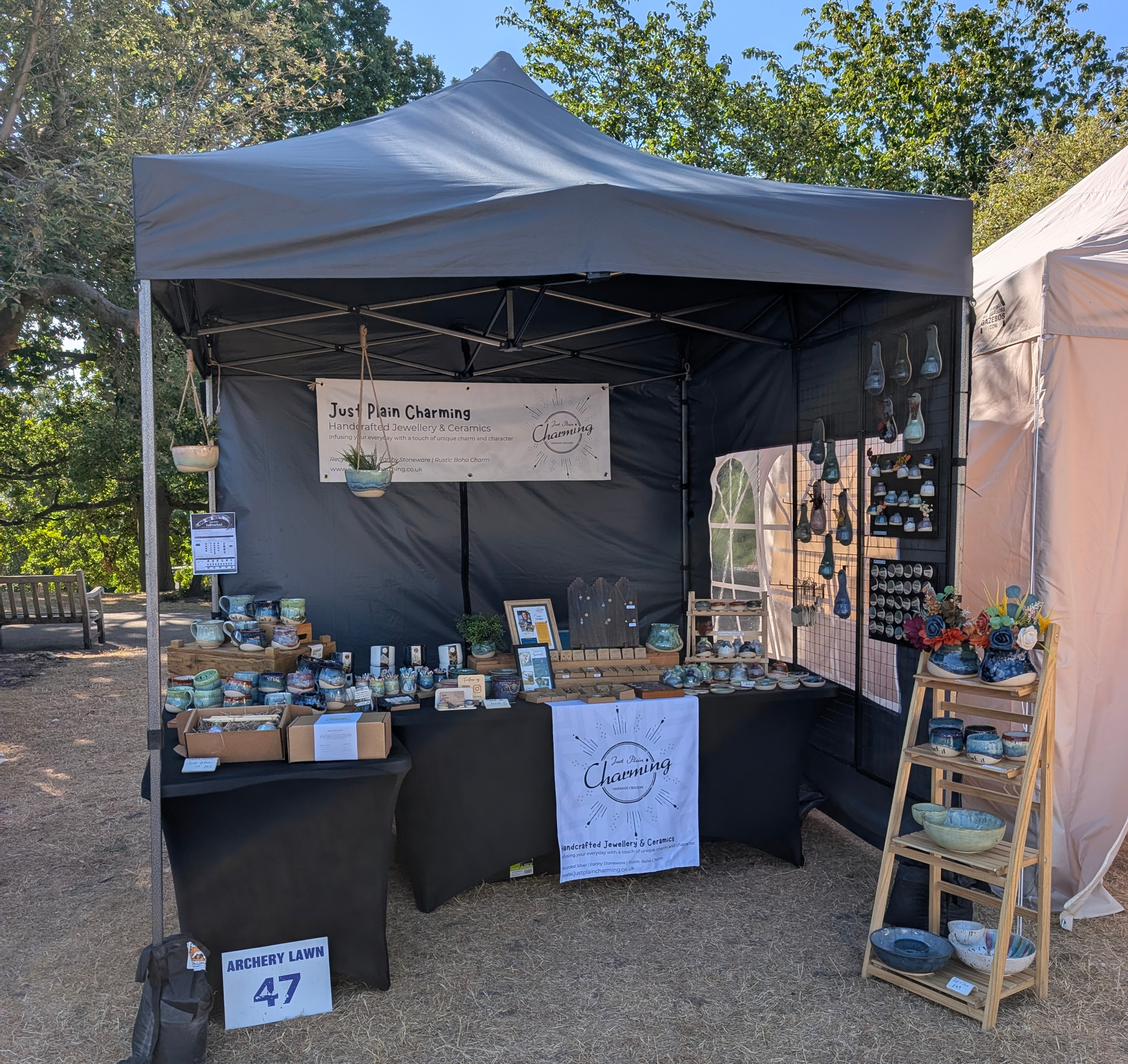A tidy set up market gazebo with handmade colourful ceramics