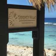 Serenity Villas sign with turquoise lagoon in the background
