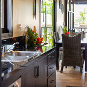 Villa dining area with rattan chairs and garden views