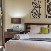 Villa bedroom with white linens and decorative wall art