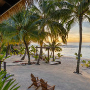 Villa deck overlooking white sand beach and palm trees