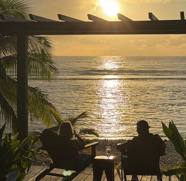 Couple enjoying sunset views from Serenity Villas beachfront gazebo