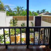 Villa balcony with timber railings overlooking tropical garden
