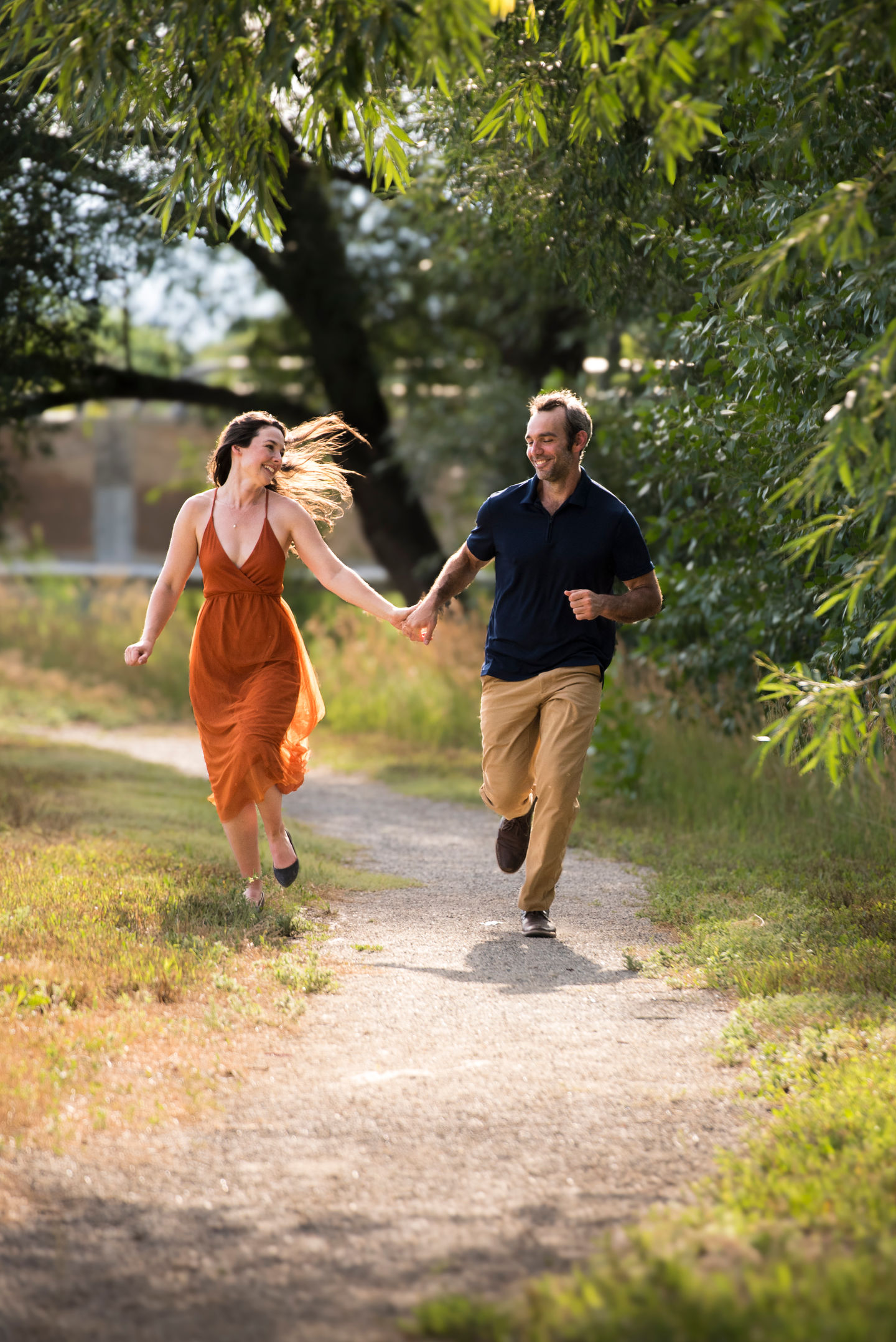 a man and a woman are running down a path holding hands