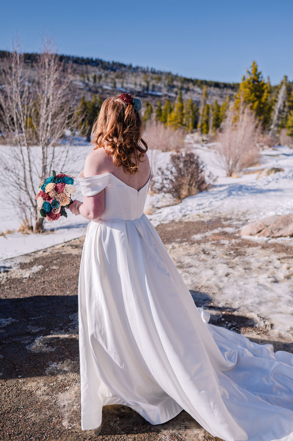 a woman in a white dress is holding a bouquet of flowers