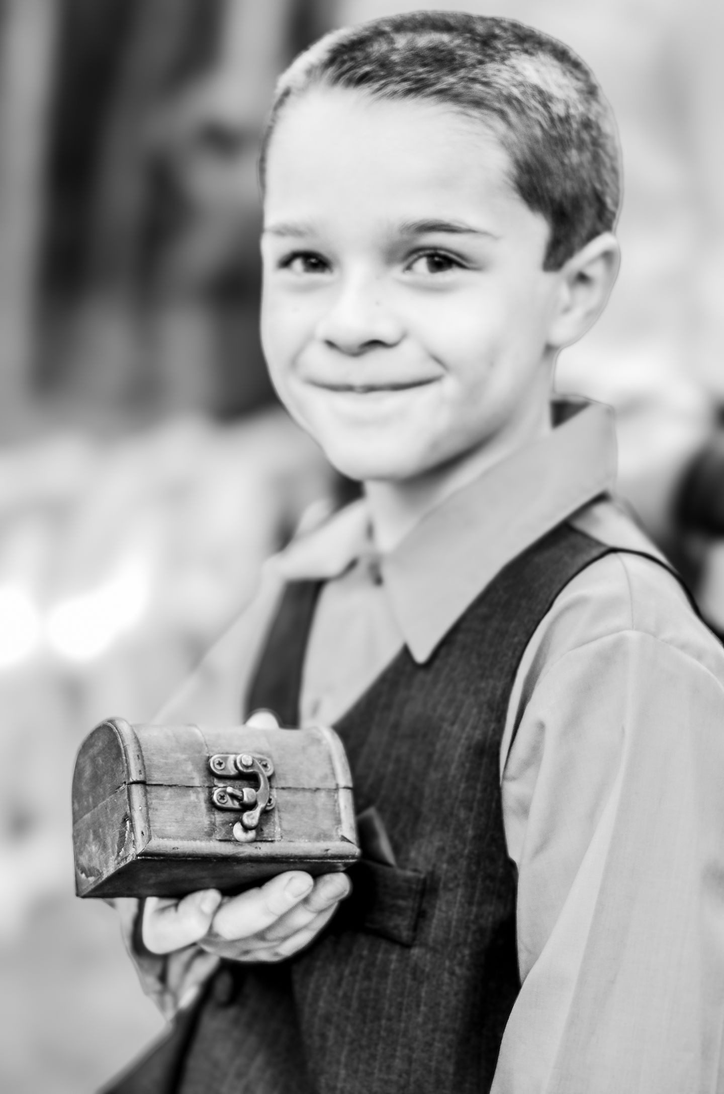 a young boy holds a small treasure chest in his hands