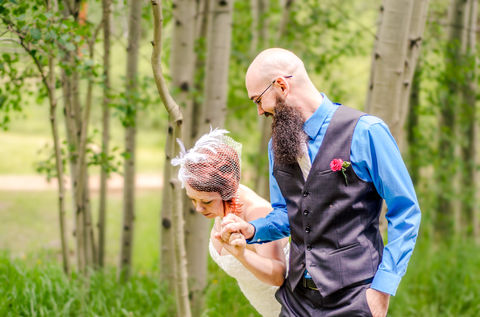 a man with a beard is holding a woman 's hand
