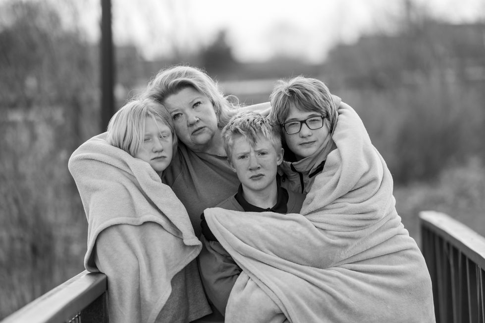 a black and white photo of a family wrapped in blankets