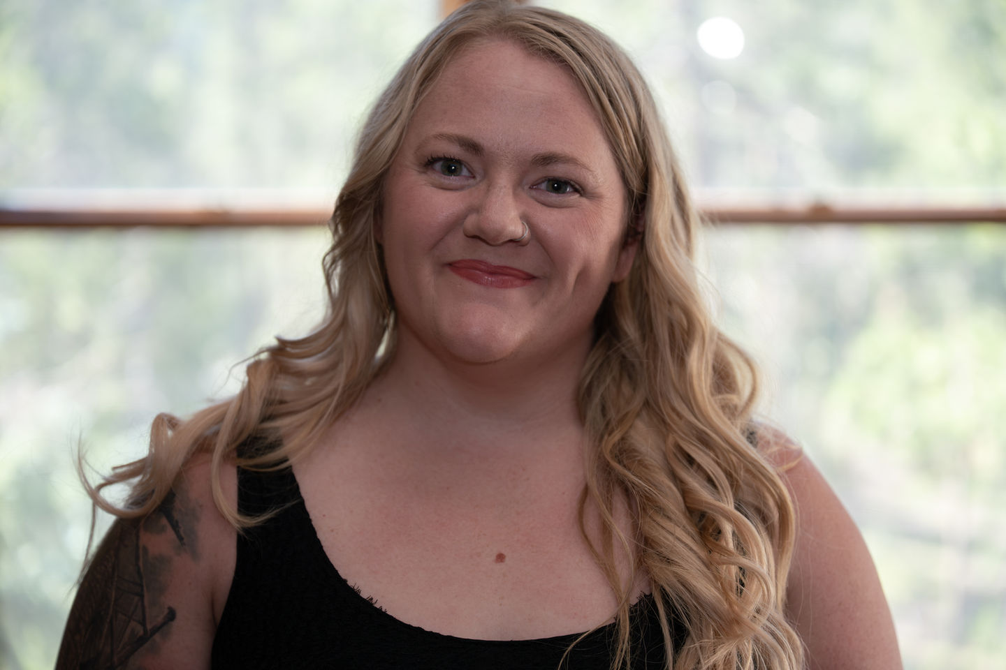 A person with long blonde hair smiling.