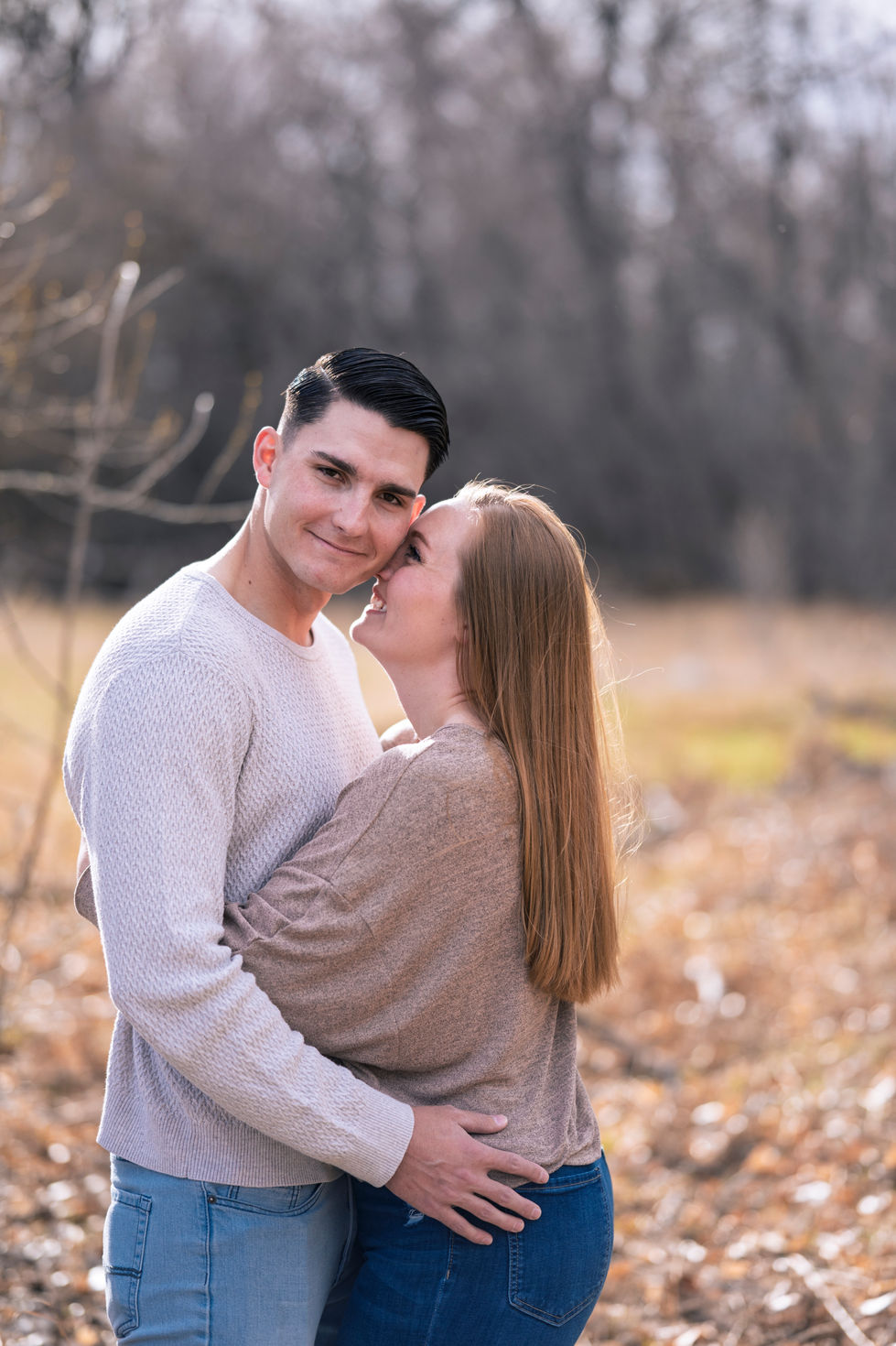 a woman kisses a man on the cheek in a field