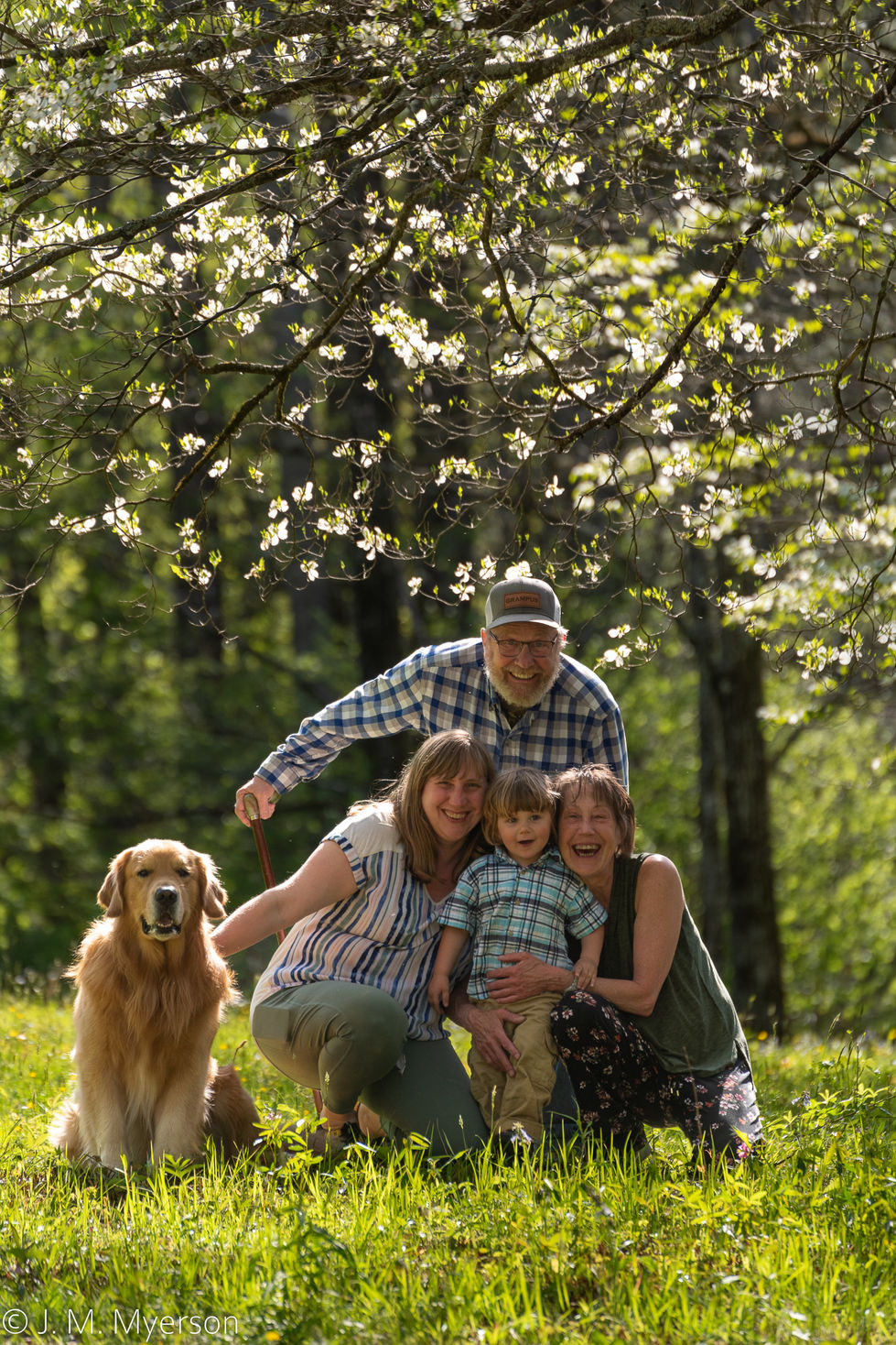 a family posing for a picture with a dog in the foreground
