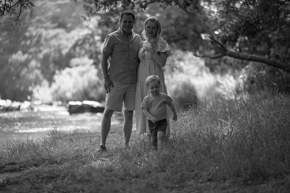 Family walking in a sunlit grassy area.
