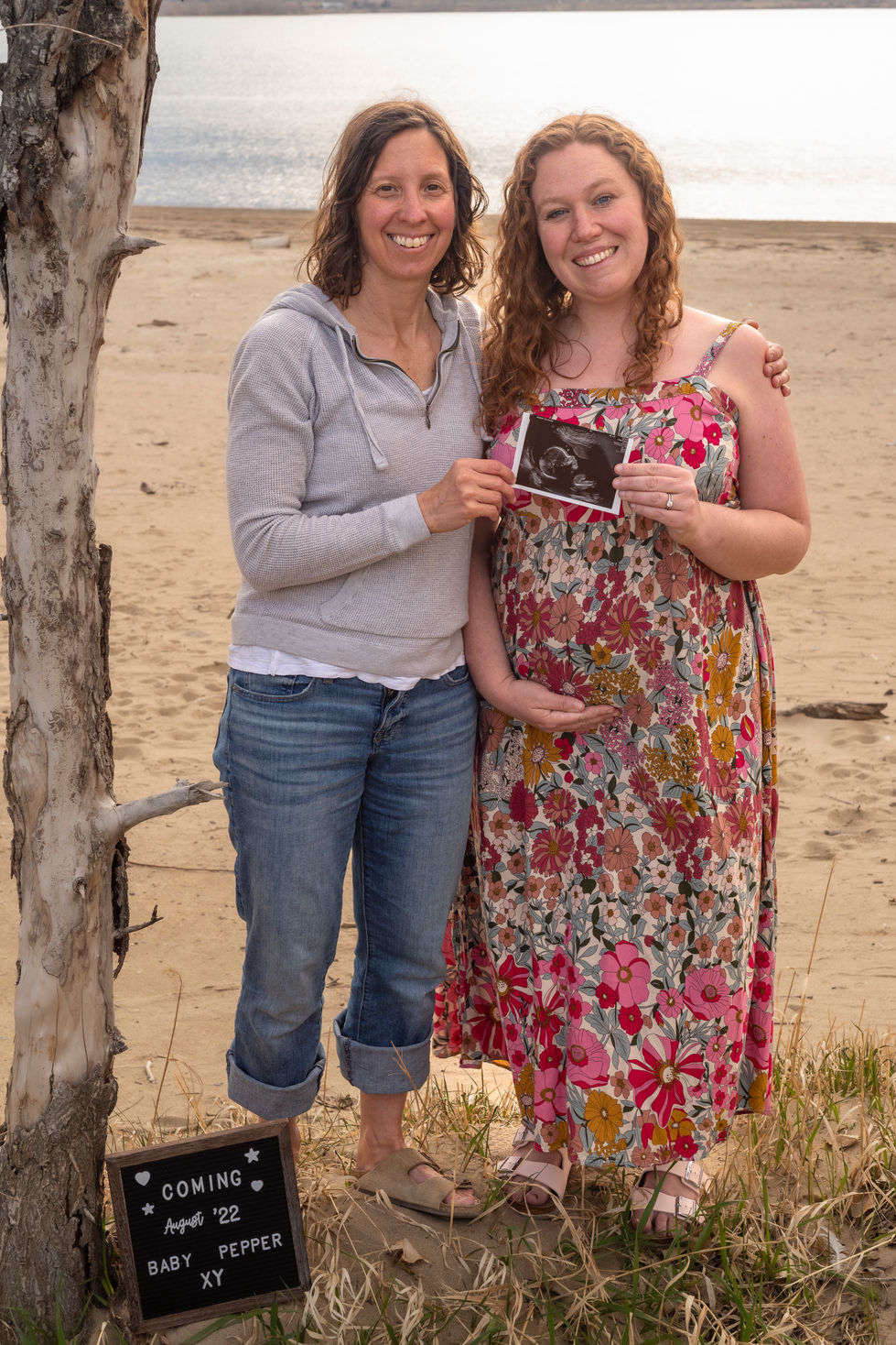 a woman in a floral dress holds a picture of a baby