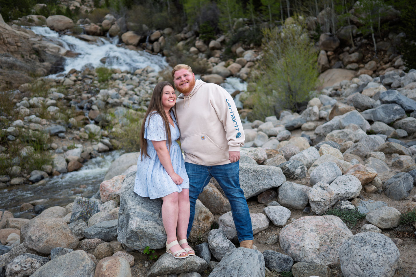 a man wearing a carhartt sweatshirt stands next to a woman