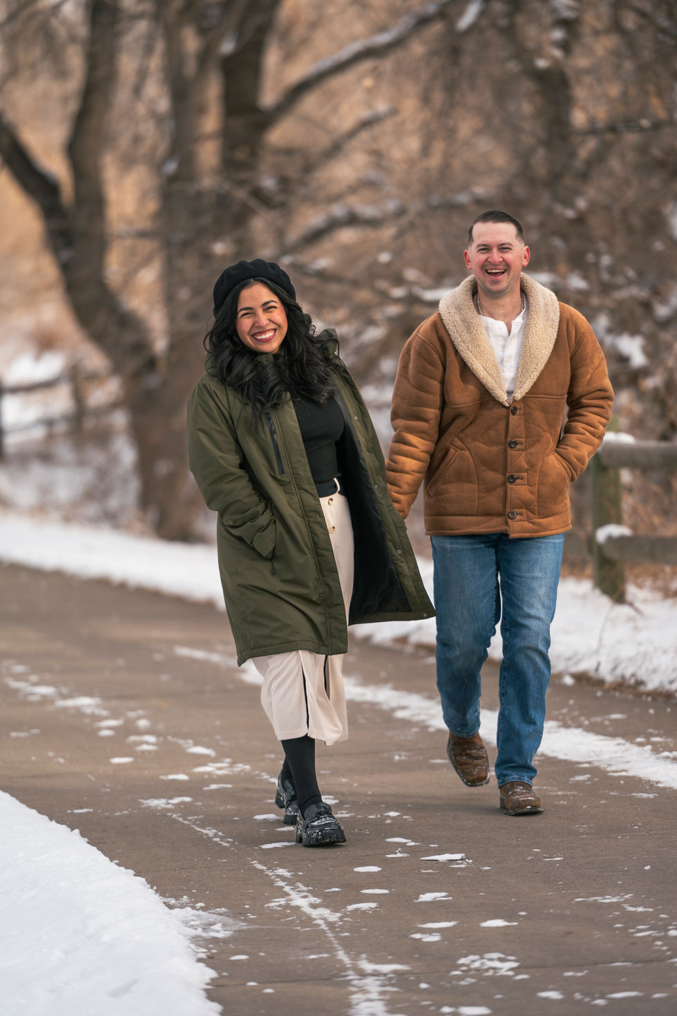 a man and a woman are walking down a snowy path