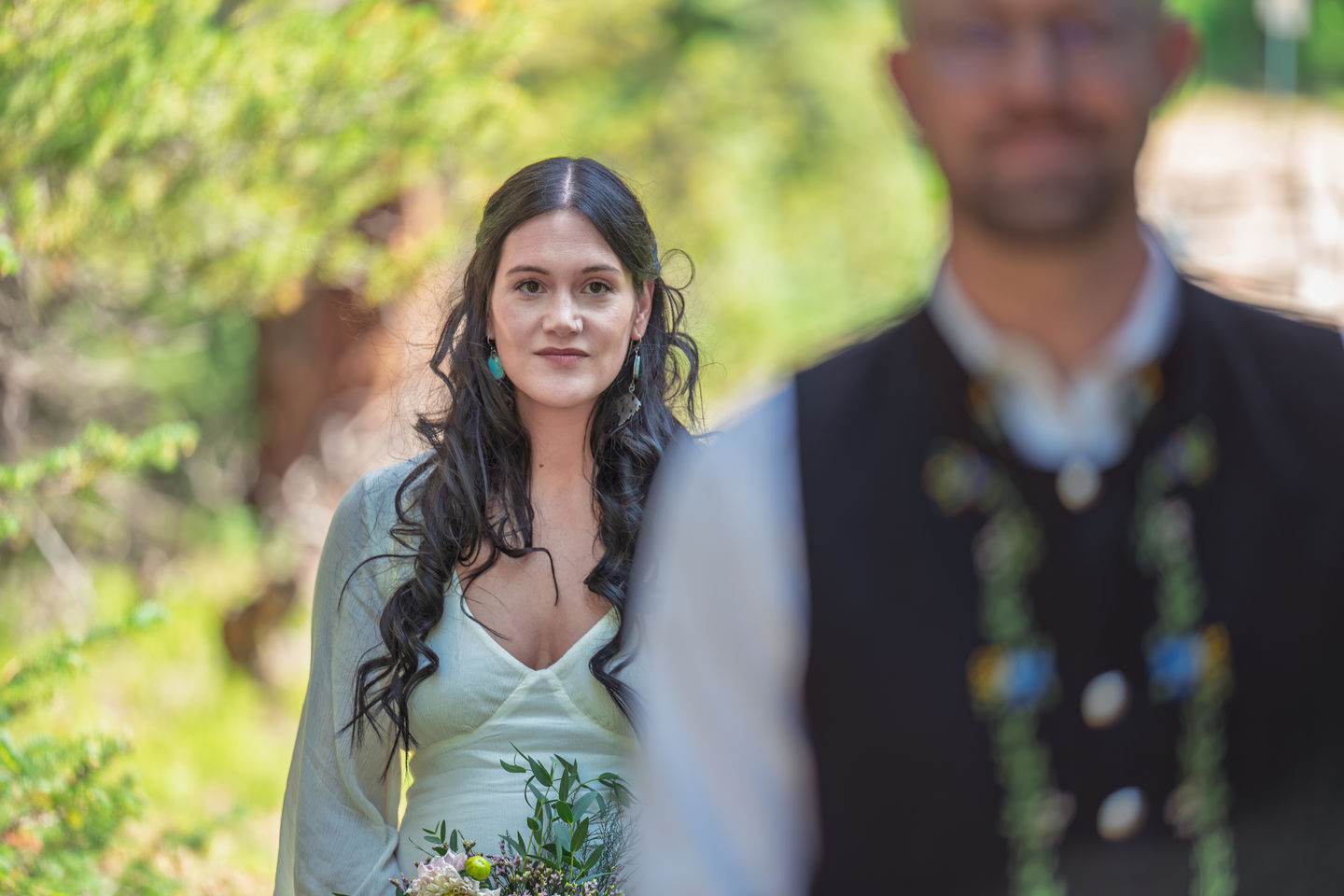Woman with long hair standing outdoors, blurred background.