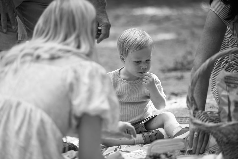 Black and white photo of children sitting outdoors.