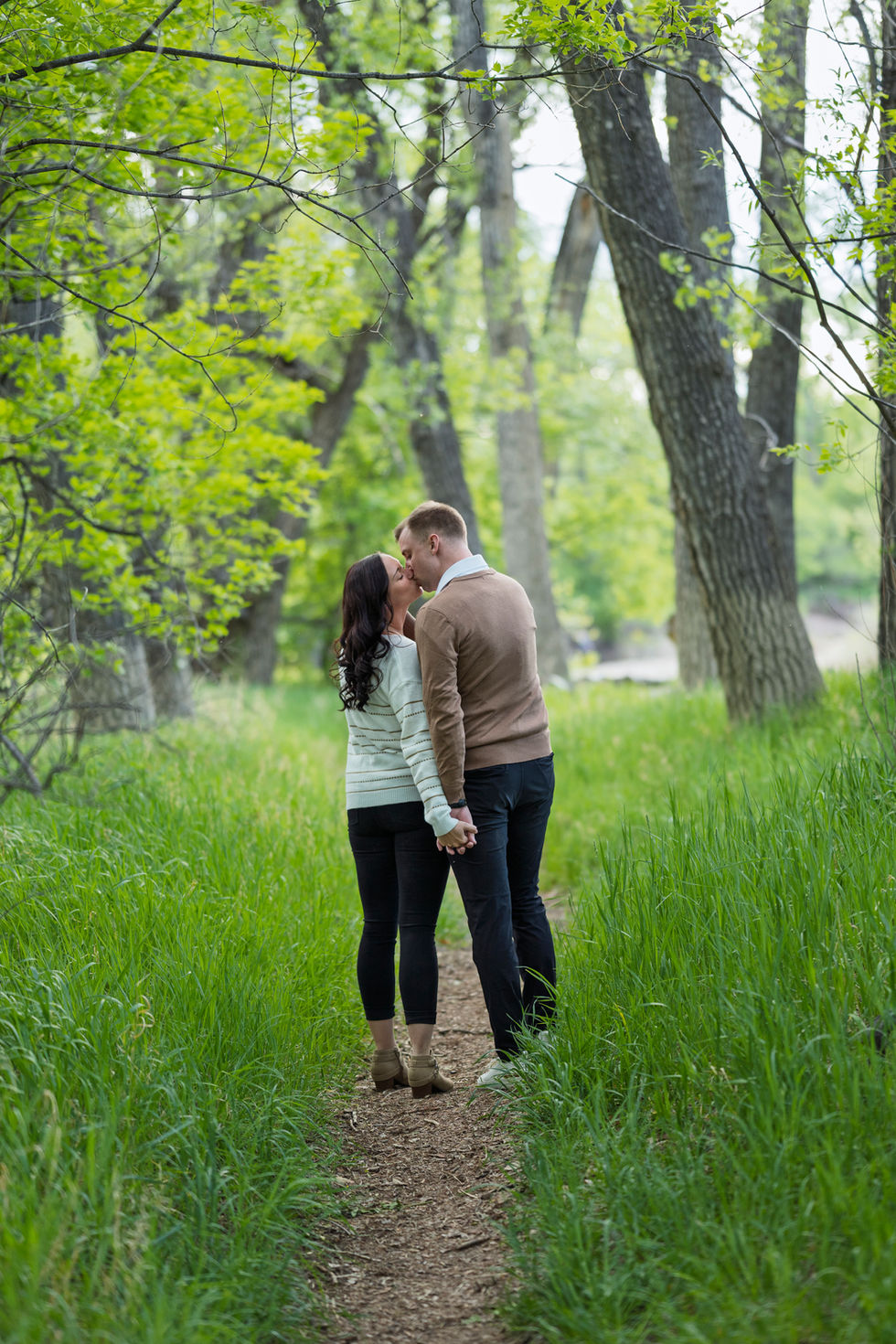 a man and a woman are kissing in the woods