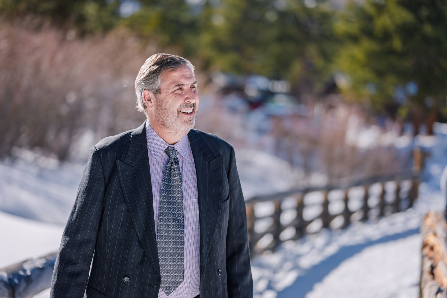 a man in a suit and tie is walking in the snow