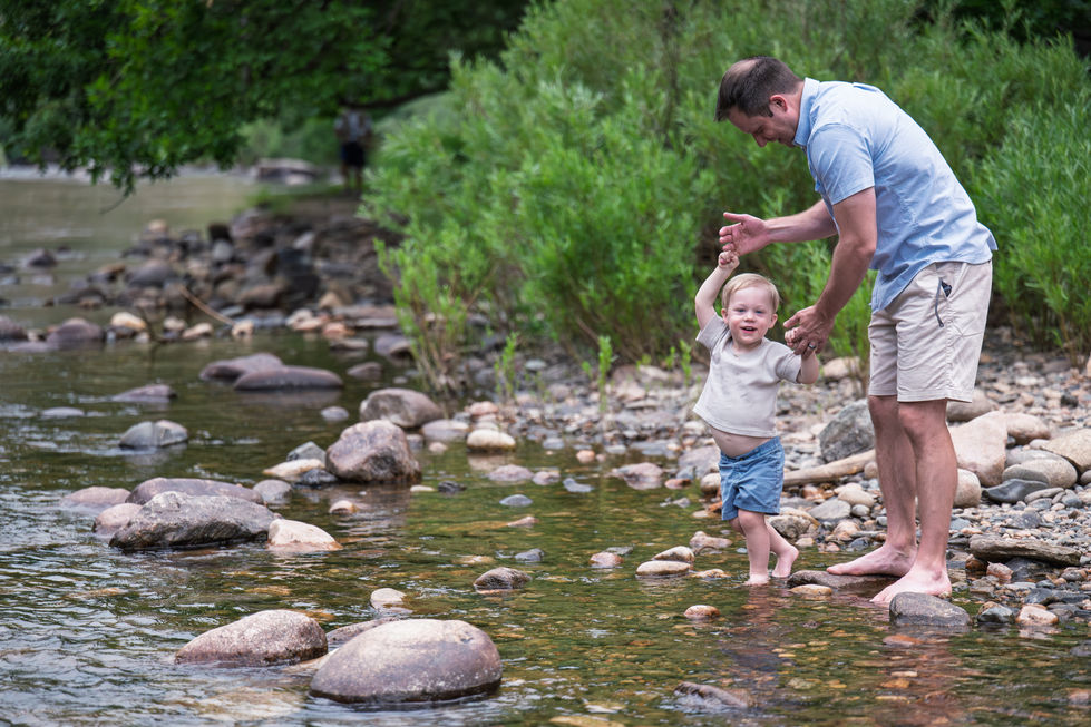 Father and child playing in a rocky stream.
