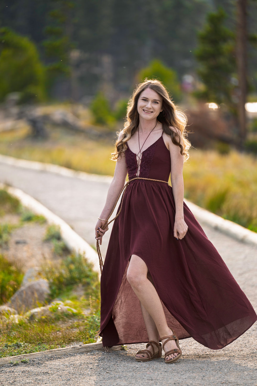 Woman in a flowing burgundy dress outdoors.