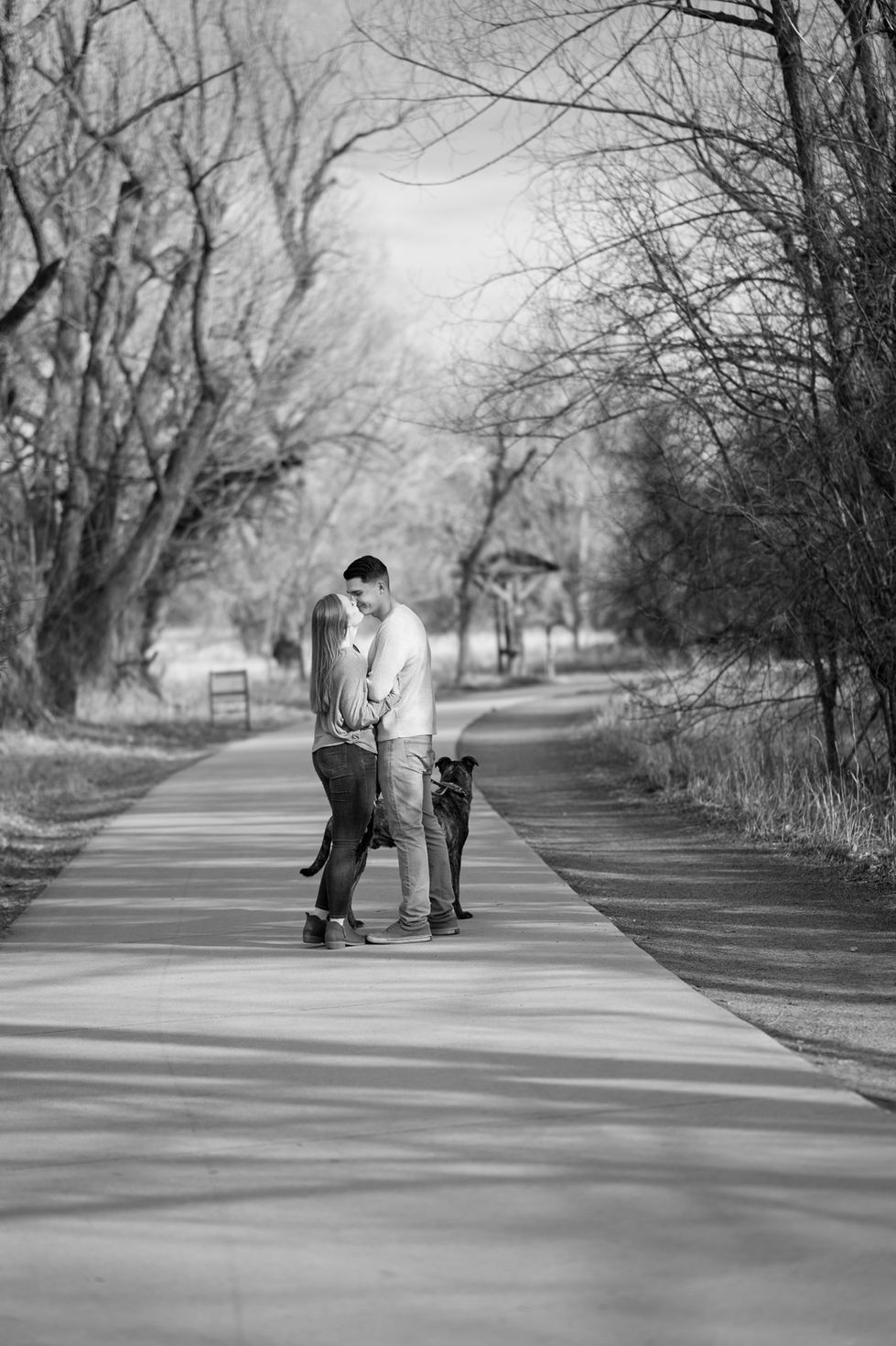 a black and white photo of a man and woman with a dog