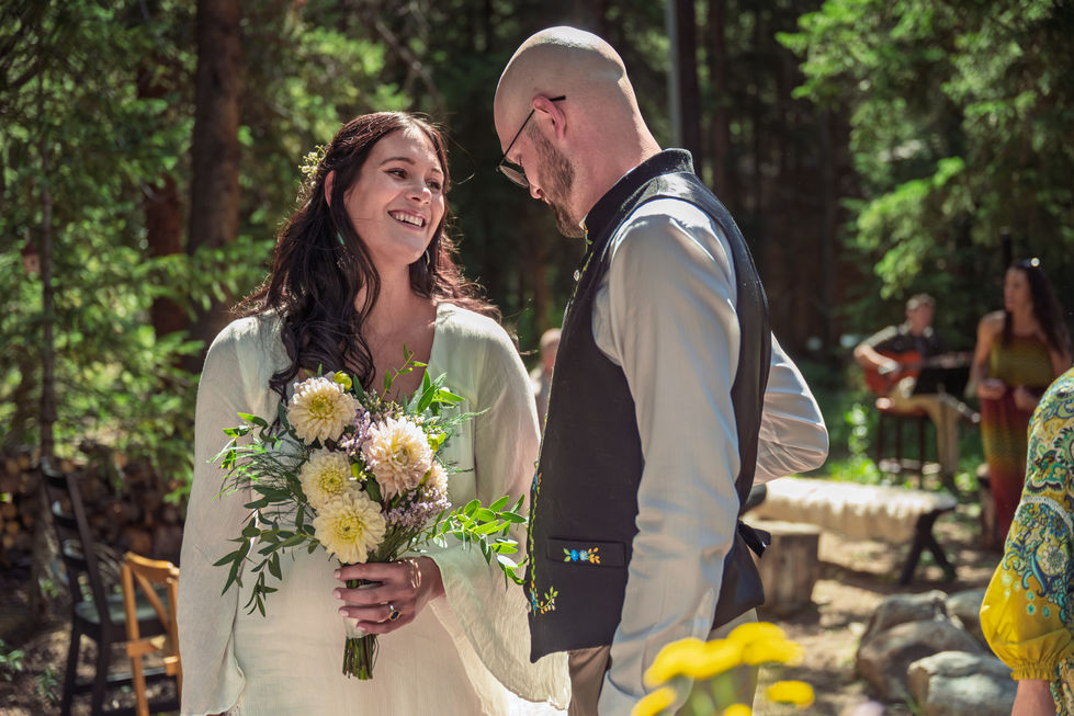 Bride and groom smiling in outdoor setting.