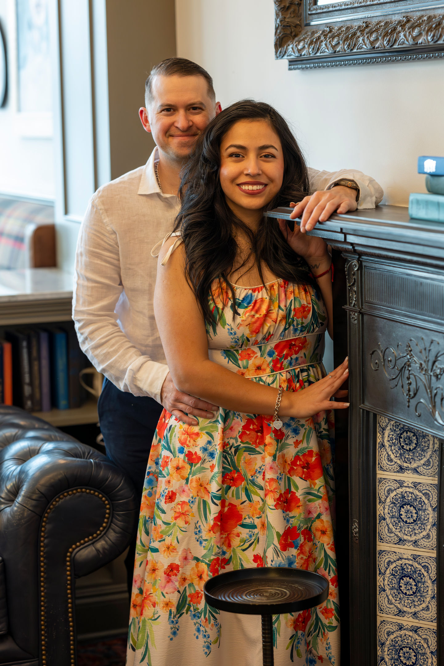 a man and woman are posing for a picture in front of a fireplace