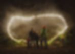A family group of two adults and three children stand together, facing away from the viewer. They are outside and it is dark except for the fairy lights illuminating a giant canopy that covers a rustic seating area and campfire. They are wearing woolly hats and winter coats, and the feel of the image is very festive.