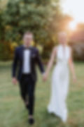 Brautpaar läuft Hand in Hand im Sonnenuntergang auf einer Wiese, fotografiert von Christian Gehrt, Hochzeitsfotograf Hannover
