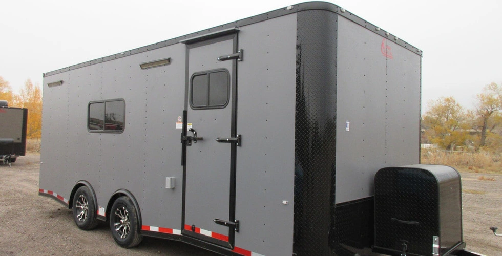 Gray enclosed cargo trailer with black diamond plate trim and tandem axles