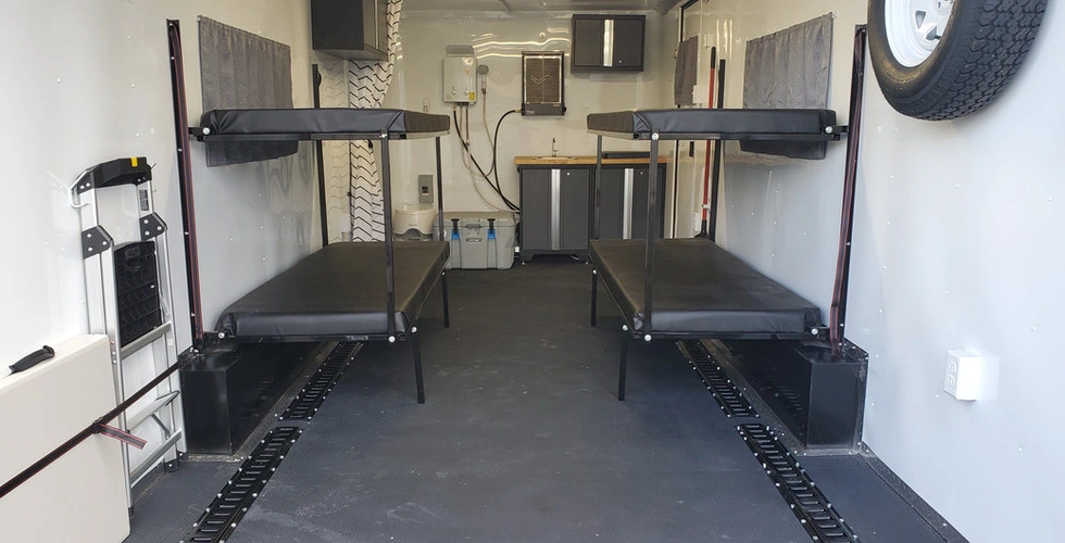 Enclosed toy hauler interior with fold-up bunk beds and E-track tie-down system