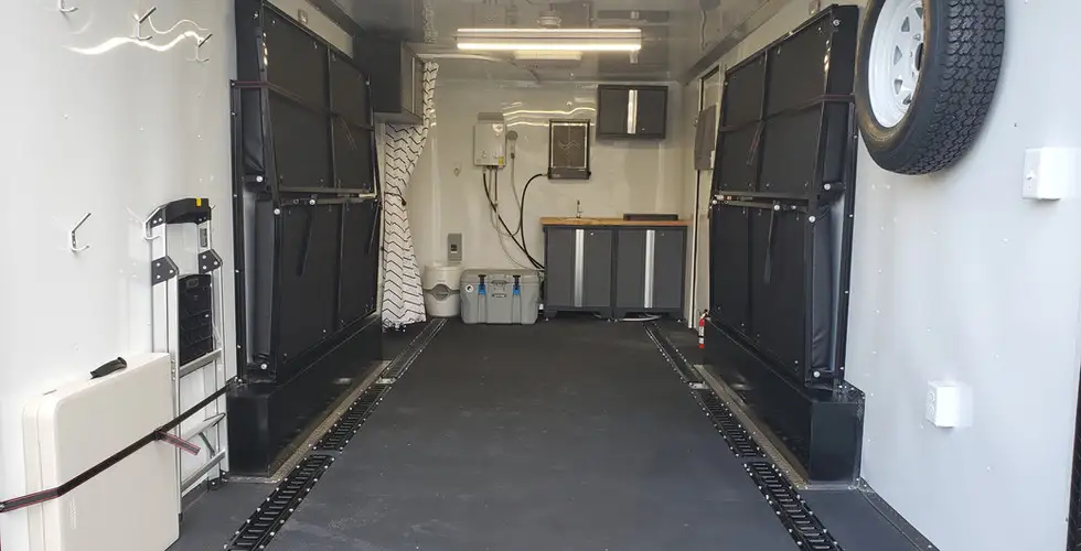 Enclosed cargo trailer interior with E-track tie-down system and side doors