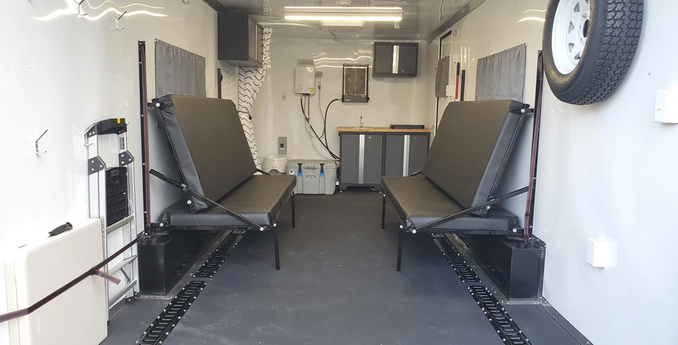 Toy hauler interior with fold-down bunk beds in seating position and LED lighting