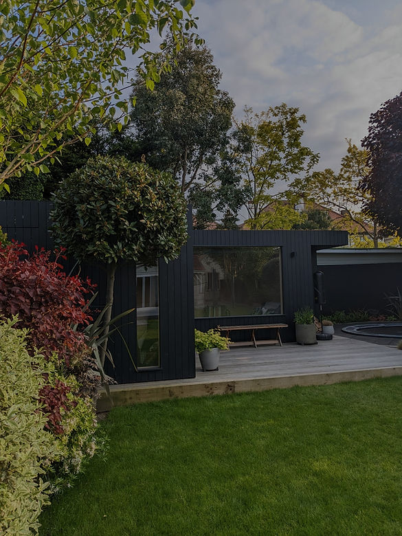 Dark wood garden room with composite decking and shrub borders_edited.jpg