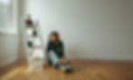 Woman sits on floor, paint cans nearby