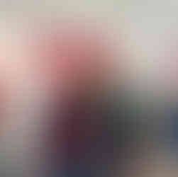 Two women posing with their arms around their shoulders and smiling in an art gallery with very colorful silly art